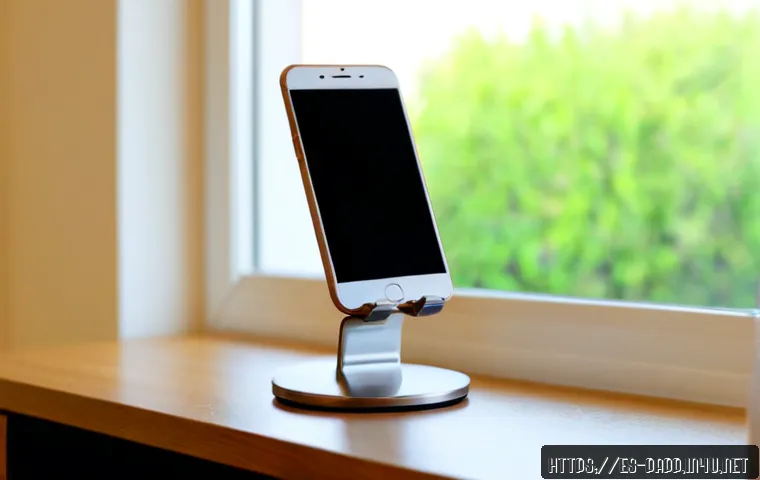 스마트폰 화면 거치대 - Photorealistic close-up of a modern adjustable smartphone screen stand holding a blank phone in port...